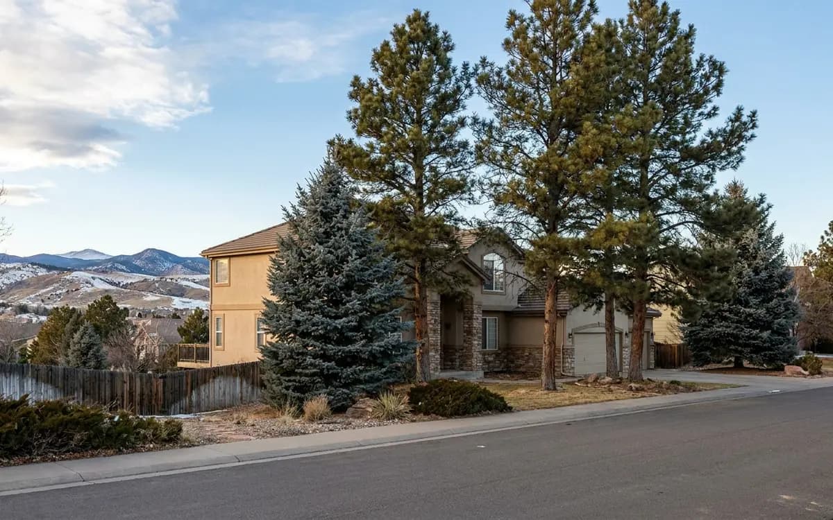 Highlands Ranch home with mature pines and foothills beyond