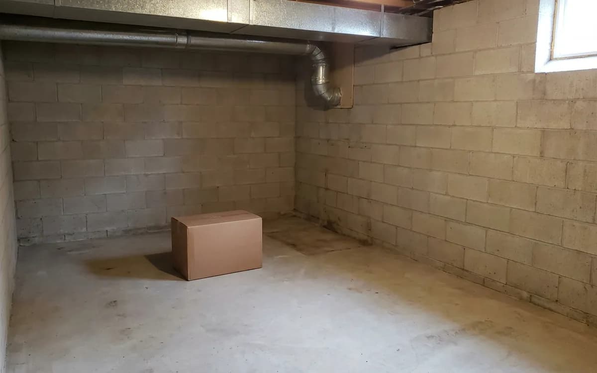 Clean empty utility alcove with ductwork and an unmarked box, prepared for replacement