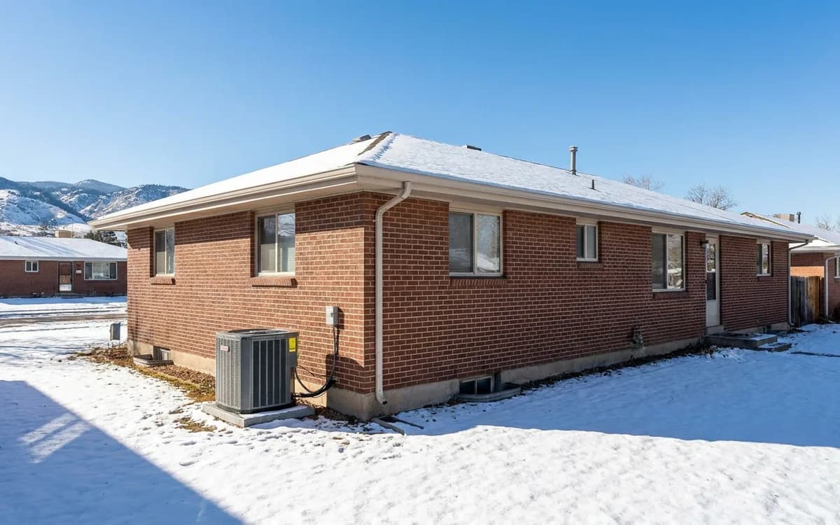 Snowy Denver-area home with a generic outdoor HVAC unit and foothills