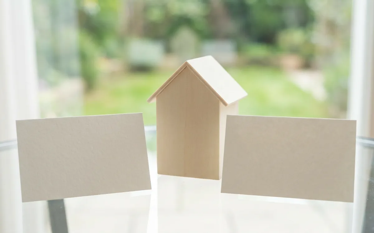 Two blank comparison cards with a small house model