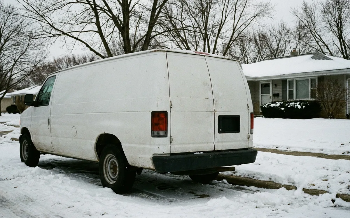 Technician carrying tools toward a home entrance in low winter light